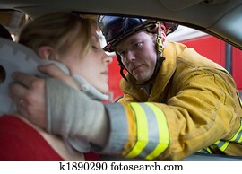 Firefighters helping an injured woman in a car Firefighters helping an injured woman in a car