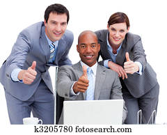 Business people with thumbs up looking at a laptop