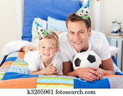 Happy child and his father playing with a soccer ball