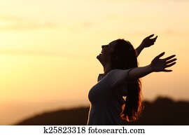 Back light of a woman breathing raising arms