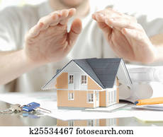 Conceptual Hands Covering Miniature Model Home