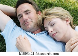 Couple lying outdoors sleeping