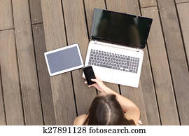 mulher, usando, múltiplo, dispositivos, telefone, laptop, e, tabuleta