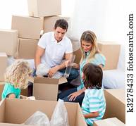Blissful family packing boxes while moving house