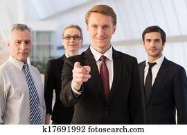 wille, sie, zusammenfuehren, unser, team?, sicher, junger mann, in, formalwear, zeigen, sie, und, lächeln, während, seine, kollegen, stehen, ihm