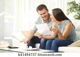 Couple reading mail at home Couple reading mail at home