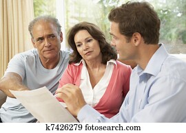Senior Couple With Financial Advisor At Home