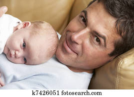 Portrait Of Father With Newborn Baby At Home