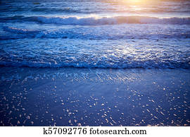 Golden glow of sunset over gently lapping waves