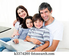 Jolly family at home using a laptop