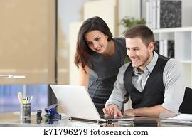 Happy boss teaching intern at office Happy boss teaching intern at office