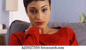Sad black woman sitting on couch