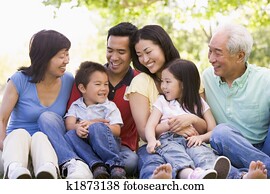 Extended family sitting outdoors smiling Extended family sitting outdoors smiling