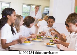 Schoolchildren enjoying their lunch in a school cafeteria Schoolchildren enjoying their lunch in a school cafeteria
