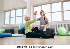 Senior woman rejoicing health success with her instructor