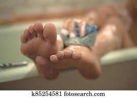 Women's foots in the bathroom. The girl bathes. Photo is out of focus. Women's foots in the bathroom. The girl bathes. Photo is out of focus.