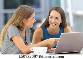 Two happy friends talking about on line content