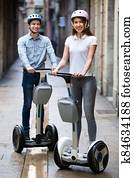 Positive boy and girl posing on segways in vacation Positive boy and girl posing on segways in vacation