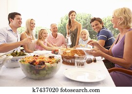 A family, with parents, children and grandparents, enjoy a picnic A family, with parents, children and grandparents, enjoy a picnic
