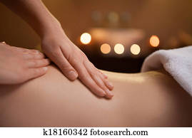 gentle hand massage of girl back. burning candles on background near sink