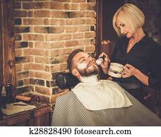 Client during beard shaving in barber shop Client during beard shaving in barber shop