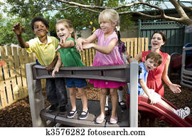 Preschool children playing on playground with teacher Preschool children playing on playground with teacher