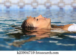 Profile of a beauty relaxed woman face floating in water