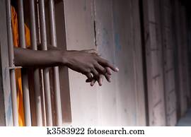Prisoner's Arms Resting on Cell Bars