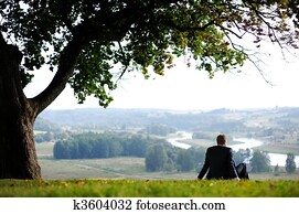 Business man resting under an oak 