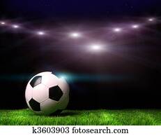 Soccer ball on grass against black Soccer ball on grass against black