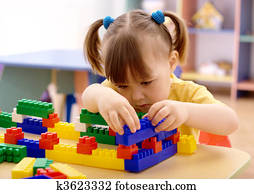 Little girl play with building bricks in preschool Little girl play with building bricks in preschool