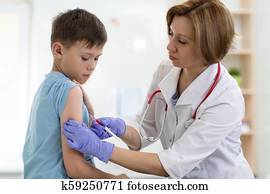 Doctor gives injection to boy's arm Doctor gives injection to boy's arm