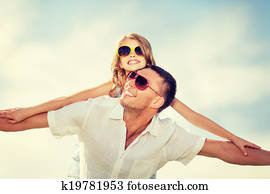 happy father and child in sunglasses over blue sky