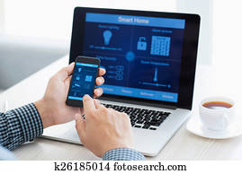 man holding phone with program smart home on the screen