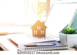 Wood house model on computer laptop