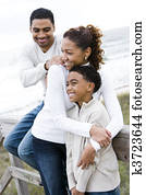 African-American family hugging at beach