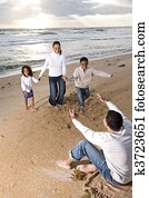 African-American family running to dad on beach