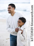 African-American father and son on beach