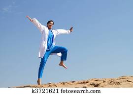 cheerful nurse jumping on beach