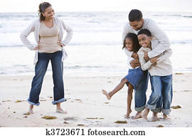 Happy African-American family laughing on beach