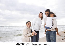 Happy African-American family of four on beach