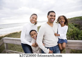 Happy African-American family of four on beach