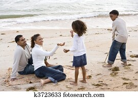Happy African-American family playing on beach