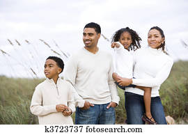 Happy African-American family standing together at beach