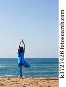 nurse doing yoga on beach