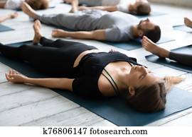Beautiful woman meditating in Savasana pose close up, practicing yoga Beautiful woman meditating in Savasana pose close up, practicing yoga