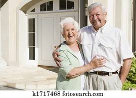 Senior couple standing outside their home Senior couple standing outside their home