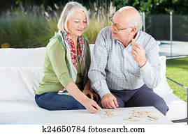 Happy Senior Couple Playing Dominoes At Porch