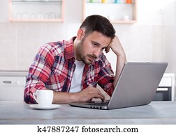 Bored man looking at laptop Bored man looking at laptop