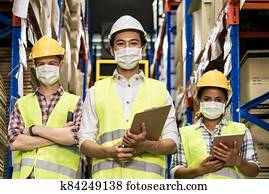 Interracial warehouse worker team with face mask Interracial warehouse worker team with face mask